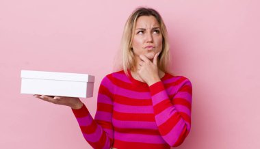 Sarışın, güzel, düşünceli, kuşkulu ve kafası karışık bir kadın. beyaz kutu kavramı