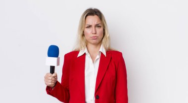 Sarışın, güzel bir kadın üzgün ve mızmızlanıyor. Mutsuz bir bakışı var ve ağlıyor. preporter ve mikrofon kavramı