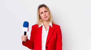 Sarışın, güzel kadın kafası karışık ve şaşkın hissediyor. preporter ve mikrofon kavramı