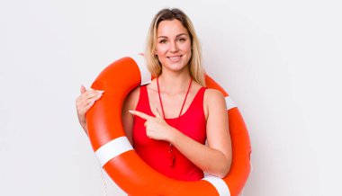 Sarışın, güzel bir kadın neşeyle gülümsüyor, mutlu hissediyor ve bir tarafı işaret ediyor. cankurtaran konsepti