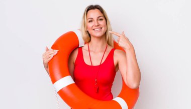 Sarışın, güzel bir kadın, kendine güvenerek gülümsüyor. cankurtaran konsepti