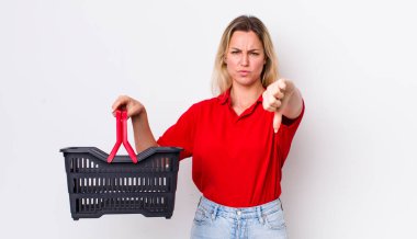 Sarışın, güzel bir kadın kendini kötü hissediyor, baş parmağını kaldırıyor. Alışveriş sepeti konsepti