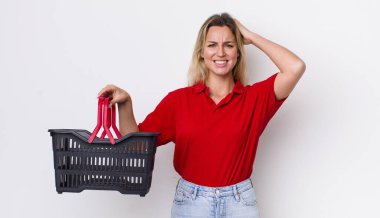 Sarışın, güzel bir kadın stresli, endişeli ya da korkmuş, elleri başının üstünde. Alışveriş sepeti konsepti