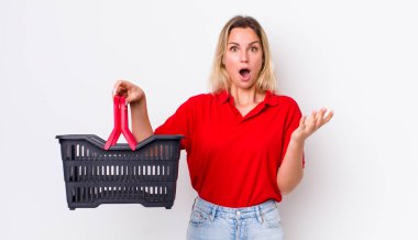 Sarışın, güzel bir kadın son derece şaşırmış ve şok olmuş hissediyor. Alışveriş sepeti konsepti