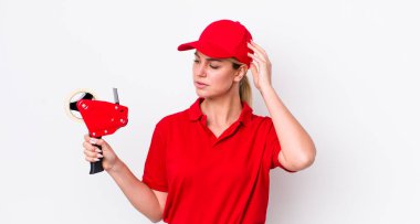 Kafası karışmış, kafası karışmış, kaşınan güzel sarışın bir kadın. işçi konsepti