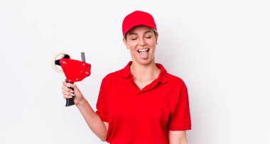 Sarışın, güzel, neşeli ve asi tavırlı, şaka yapan ve dilini dışarı çıkaran bir kadın. işçi konsepti