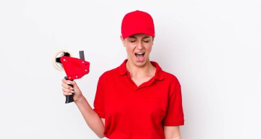 Sarışın, güzel bir kadın agresif bir şekilde bağırıyor, çok kızgın görünüyor. işçi konsepti