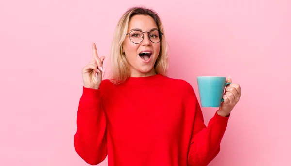 アイデアを実現した後に幸せと興奮の天才のように感じるブロンドのかなりの女性 コーヒーカップのコンセプト — ストック写真