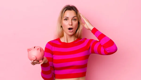 Blonde Pretty Woman Looking Happy Astonished Surprised Piggy Bank Concept — Stockfoto