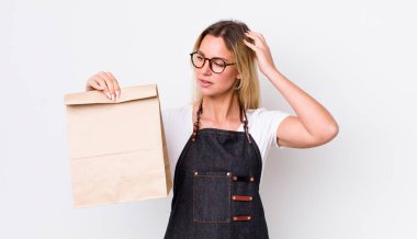 Kafası karışmış, kafası karışmış, kaşınan güzel sarışın bir kadın. teslimat paket servis kavramı