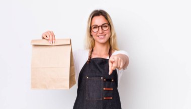 Sarışın, güzel bir kadın seni seçen kamerayı işaret ediyor. teslimat paket servis kavramı