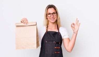 Sarışın, güzel bir kadın kendini mutlu hissediyor. Onayını veriyor. teslimat paket servis kavramı