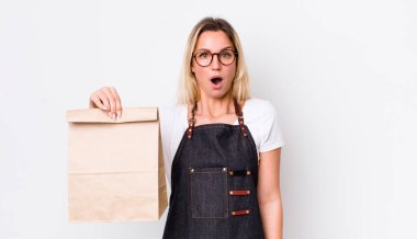 Sarışın, güzel bir kadın çok şaşırmış ya da şaşırmış görünüyor. teslimat paket servis kavramı