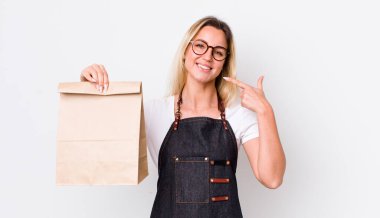 Sarışın, güzel bir kadın, kendine güvenerek gülümsüyor. teslimat paket servis kavramı