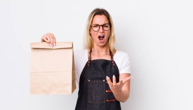 Sarışın, güzel bir kadın sinirli, sinirli ve sinirli görünüyor. teslimat paket servis kavramı