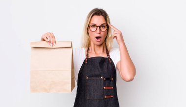 Sarışın, güzel bir kadın şaşırmış görünüyor, yeni bir düşünce, fikir ya da konsept fark ediyor. teslimat paket servis kavramı