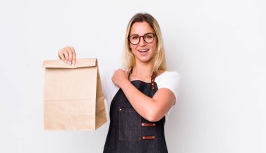 Sarışın, güzel bir kadın kendini mutlu hissediyor ve bir meydan okumayla yüzleşiyor ya da kutluyor. teslimat paket servis kavramı