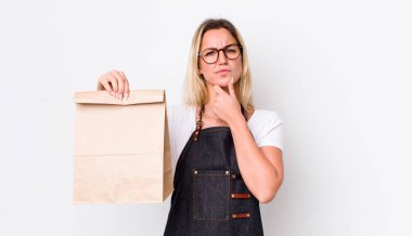 Sarışın, güzel, düşünceli, kuşkulu ve kafası karışık bir kadın. teslimat paket servis kavramı