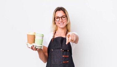 Sarışın, güzel bir kadın seni seçen kamerayı işaret ediyor. kahve konseptini kaldır.