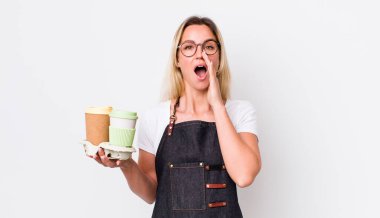 Sarışın, güzel bir kadın kendini mutlu hissediyordu. Elleri ağzının kenarında bağırıyordu. kahve konseptini kaldır.