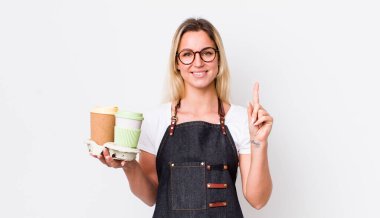 Sarışın, güzel bir kadın gülümsüyor ve arkadaş canlısı görünüyor. Bir numarayı gösteriyor. kahve konseptini kaldır.