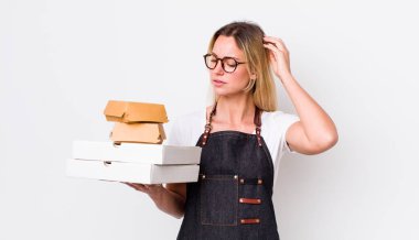 Sarışın, güzel bir kadın mutlu bir şekilde gülümsüyor ve hayal kuruyor. Fast food konseptini kaldır.