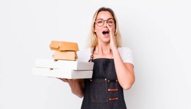 Sarışın, güzel bir kadın kendini mutlu hissediyordu. Elleri ağzının kenarında bağırıyordu. Fast food konseptini kaldır.