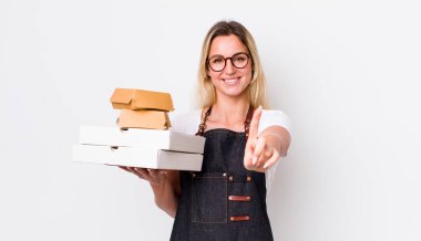 Sarışın, güzel bir kadın gururla gülümsüyor ve kendinden emin bir numara oluyor. Fast food konseptini kaldır.