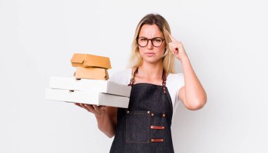 Sarışın, güzel bir kadın şaşkın ve şaşkın hissediyor, deli olduğunu gösteriyor. Fast food konseptini kaldır.