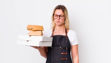 Sarışın, güzel bir kadın üzgün, üzgün ya da kızgın ve yana bakıyor. Fast food konseptini kaldır.