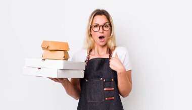 Şok olmuş ve ağzı açık, kendini gösteren sarışın, güzel bir kadın. Fast food konseptini kaldır.
