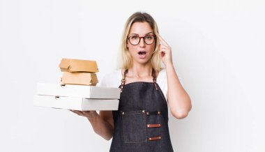 Sarışın, güzel bir kadın şaşırmış görünüyor, yeni bir düşünce, fikir ya da konsept fark ediyor. Fast food konseptini kaldır.