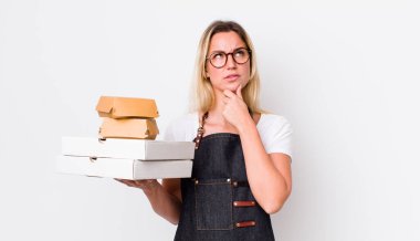 Sarışın, güzel, düşünceli, kuşkulu ve kafası karışık bir kadın. Fast food konseptini kaldır.
