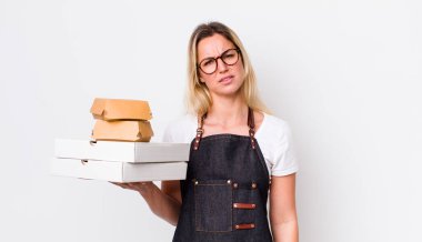 Sarışın, güzel kadın kafası karışık ve şaşkın hissediyor. Fast food konseptini kaldır.
