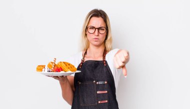 Sarışın, güzel bir kadın kendini kötü hissediyor, baş parmağını kaldırıyor. Waffle konsepti