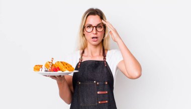 Güzel sarışın kadın mutlu, şaşkın ve şaşırmış görünüyor. Waffle konsepti