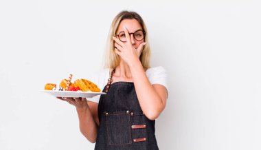 Sarışın, güzel bir kadın şok olmuş, korkmuş ya da dehşete düşmüş gibi görünüyor. Waffle konsepti