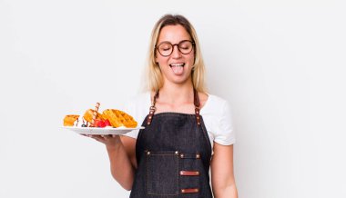 Sarışın, güzel, neşeli ve asi tavırlı, şaka yapan ve dilini dışarı çıkaran bir kadın. Waffle konsepti