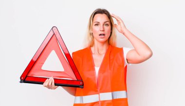 Güzel sarışın kadın mutlu, şaşkın ve şaşırmış görünüyor. araba üçgeni kaza konsepti