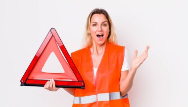 Sarışın, güzel bir kadın kendini mutlu hissediyor ve inanılmaz bir şeye hayret ediyor. araba üçgeni kaza konsepti