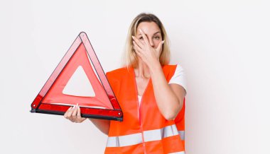 Sarışın, güzel bir kadın şok olmuş, korkmuş ya da dehşete düşmüş gibi görünüyor. araba üçgeni kaza konsepti