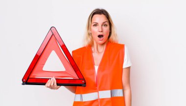 Sarışın, güzel bir kadın çok şaşırmış ya da şaşırmış görünüyor. araba üçgeni kaza konsepti