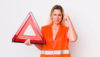 Sarışın, güzel bir kadın şaşkın ve şaşkın hissediyor, deli olduğunu gösteriyor. araba üçgeni kaza konsepti