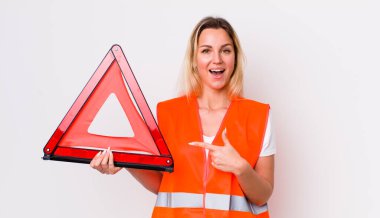 Sarışın, güzel bir kadın heyecanlı ve şaşırmış görünüyor. araba üçgeni kaza konsepti