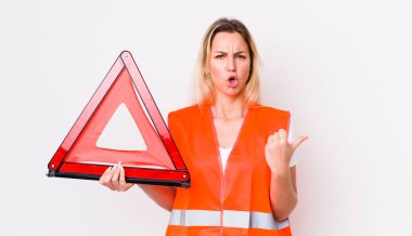 Sarışın, güzel bir kadın inançsızlıktan şaşkın şaşkın bakıyor. araba üçgeni kaza konsepti