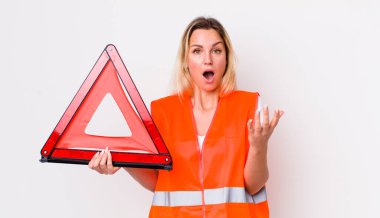 Sarışın, güzel bir kadın inanılmaz bir sürprizle şaşkına dönmüş ve hayrete düşmüştü. araba üçgeni kaza konsepti