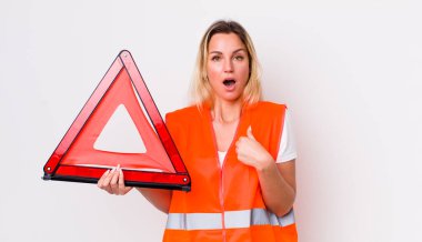 Şok olmuş ve ağzı açık, kendini gösteren sarışın, güzel bir kadın. araba üçgeni kaza konsepti