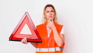 Sarışın, güzel, düşünceli, kuşkulu ve kafası karışık bir kadın. araba üçgeni kaza konsepti