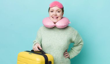 Kızıl saçlı güzel kadın mutlu bir şekilde gülümsüyor, eli kalçasında ve kendinden emin. uçuş yolcu kavramı