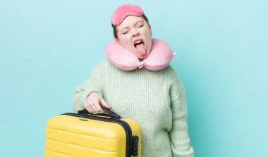 Kızıl saçlı, güzel, neşeli ve asi tavırlı, şaka yapan ve dilini dışarı çıkaran bir kadın. uçuş yolcu kavramı